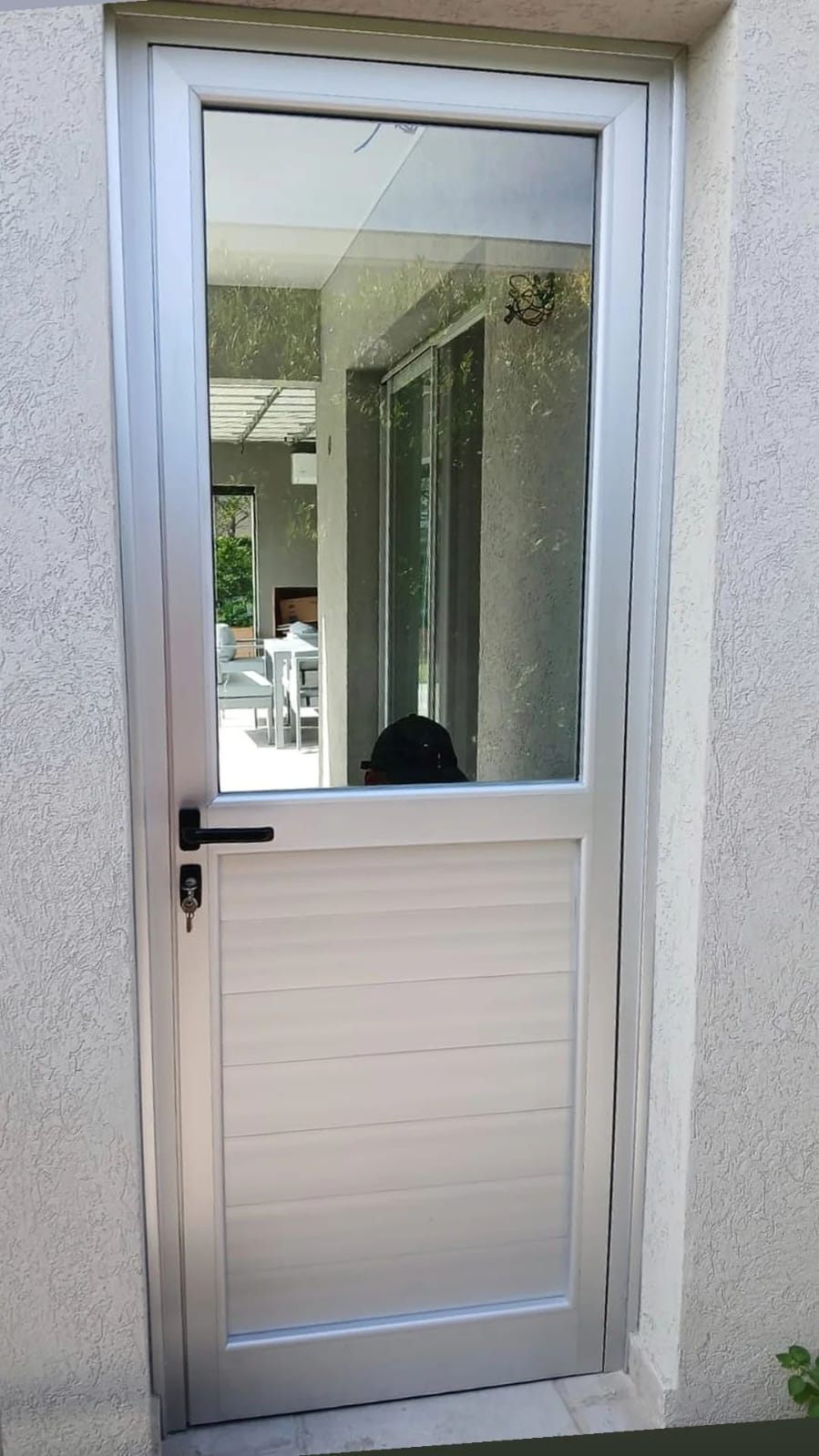 Puerta de aluminio natural con vidrio arriba y tablero abajo